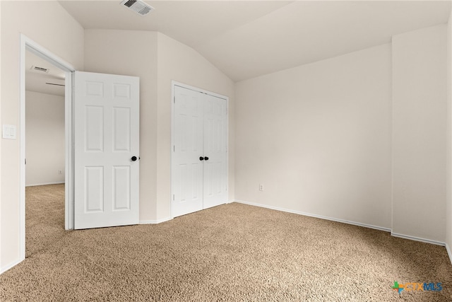 unfurnished bedroom with carpet flooring and vaulted ceiling