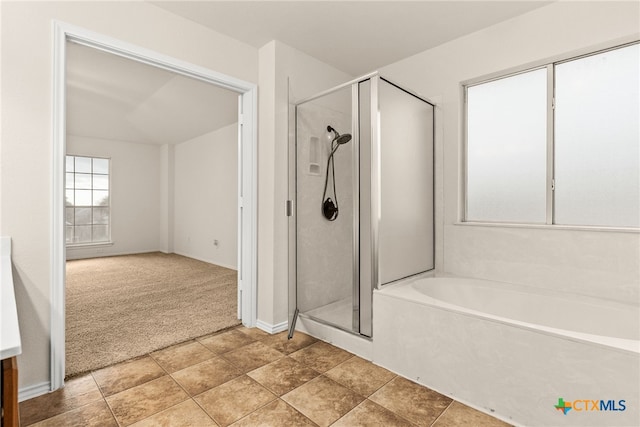 bathroom featuring shower with separate bathtub