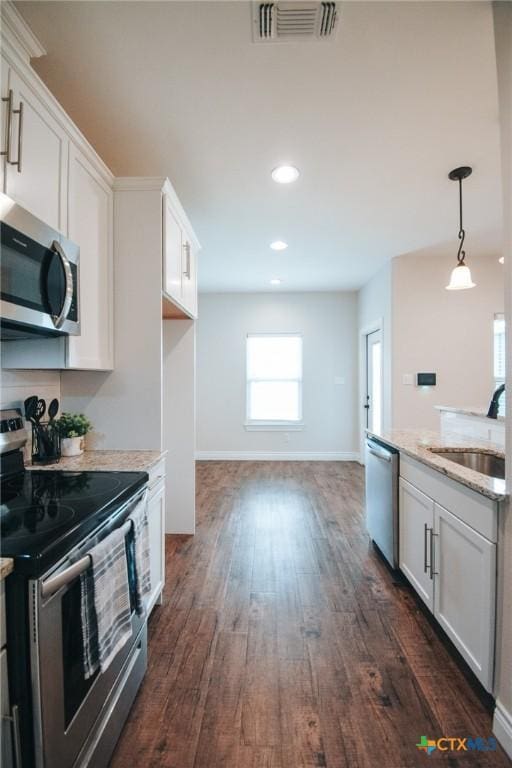 3611 Hanselman Rd, Victoria, TX 77901 - kitchen with stainless steel appliances, dark wood-type flooring, white cabinetry, recessed lighting, and light stone counters