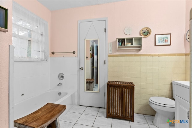 bathroom with tile walls, tile patterned flooring, a tub to relax in, and toilet