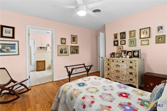 bedroom featuring ensuite bathroom, ceiling fan, and light wood-type flooring