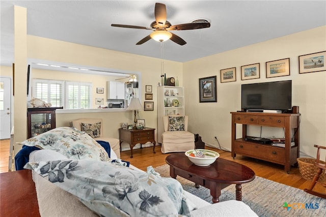 living room featuring ceiling fan and light hardwood / wood-style floors