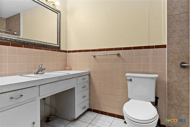 bathroom with tile walls, tile patterned flooring, vanity, and toilet