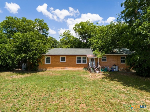 back of property featuring a yard