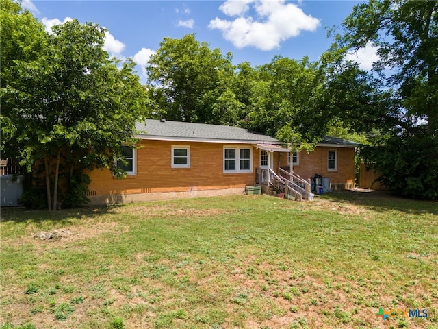 rear view of house with a yard