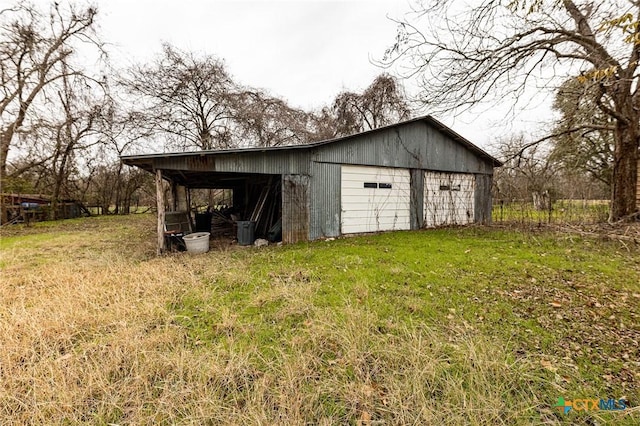 view of outdoor structure with a yard and a garage