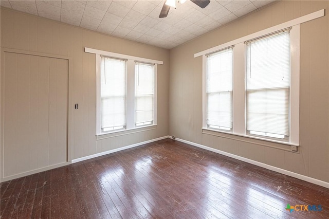 spare room featuring plenty of natural light, dark hardwood / wood-style floors, and ceiling fan