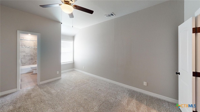 unfurnished bedroom featuring ceiling fan, ensuite bath, and light carpet