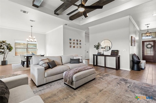 living area with a wealth of natural light, wood finished floors, visible vents, and baseboards