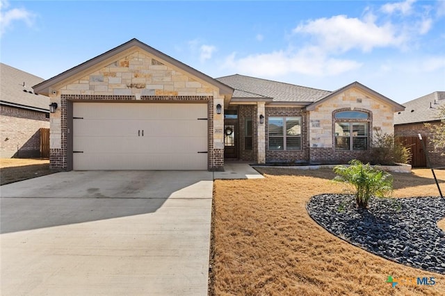 view of front of property with a garage, concrete driveway, brick siding, and stone siding