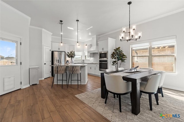 dining area with ornamental molding, wood-type flooring, and plenty of natural light