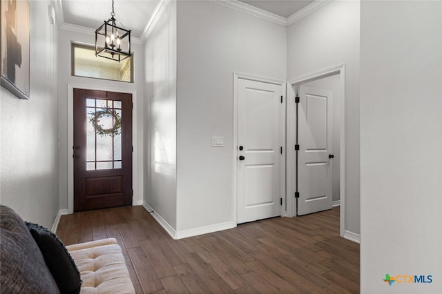 entryway with crown molding, baseboards, and wood finished floors