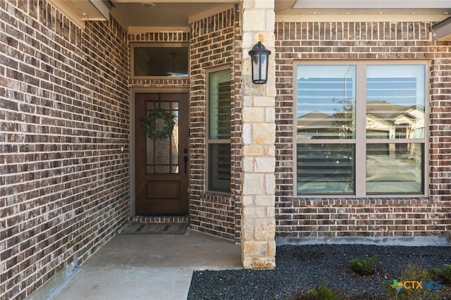 view of exterior entry with brick siding