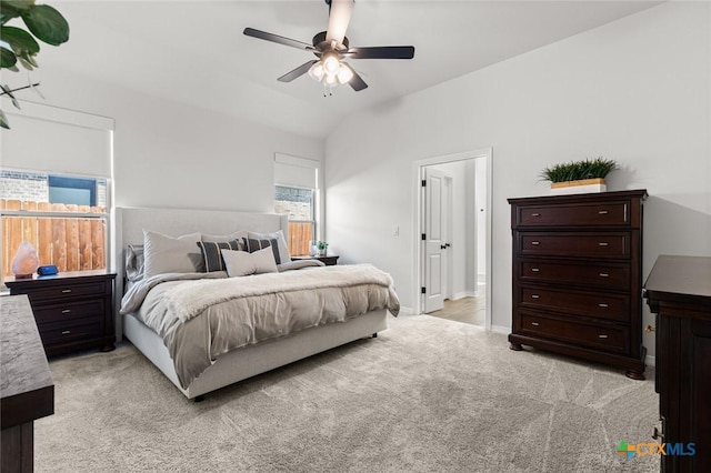 bedroom with light carpet, ceiling fan, baseboards, and vaulted ceiling