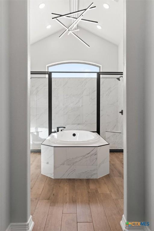 full bathroom with a chandelier, recessed lighting, a bath, and wood finished floors