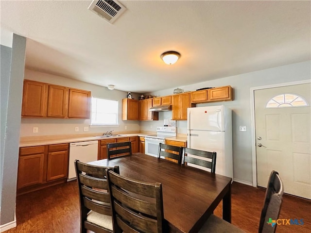 317 Aubrey St, Yoakum, TX 77995 - kitchen with white appliances, a sink, under cabinet range hood, light countertops, and brown cabinets