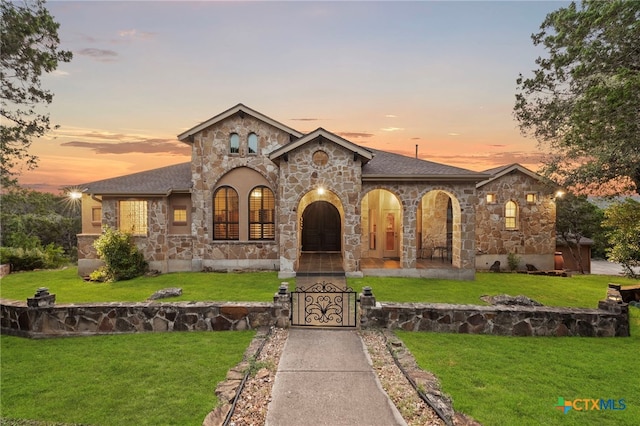 5310 River Oaks Dr, New Braunfels, TX 78132 - french country home with stone siding, a yard, a gate, and roof with shingles