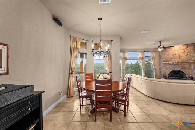 5310 River Oaks Dr, New Braunfels, TX 78132 - dining space with a chandelier, a fireplace, ceiling fan, and light tile patterned floors