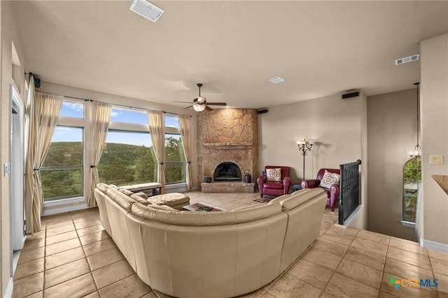 5310 River Oaks Dr, New Braunfels, TX 78132 - living room featuring a fireplace, ceiling fan, plenty of natural light, and light tile patterned floors
