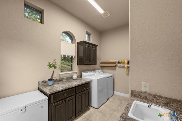 5310 River Oaks Dr, New Braunfels, TX 78132 - laundry room featuring cabinet space, independent washer and dryer, a textured wall, and light marble finish flooring