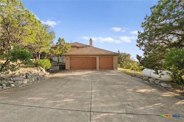 5310 River Oaks Dr, New Braunfels, TX 78132 - view of property exterior with stucco siding, a chimney, and a garage