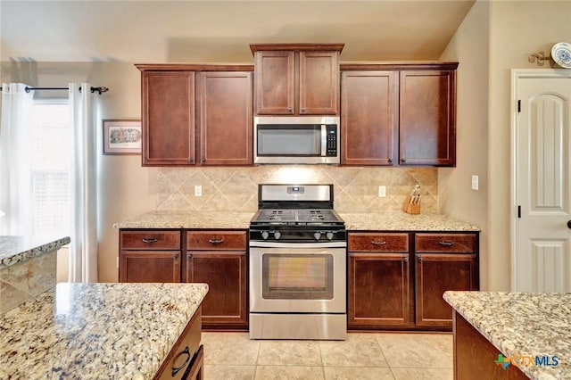 106 Cobble Stone Ct, Victoria, TX 77904 - kitchen with stainless steel appliances, light stone counters, decorative backsplash, and light tile patterned flooring