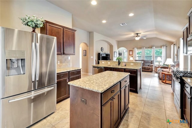 106 Cobble Stone Ct, Victoria, TX 77904 - kitchen with appliances with stainless steel finishes, a kitchen island, arched walkways, open floor plan, and a ceiling fan