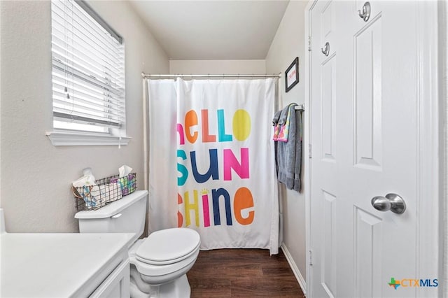 bathroom with toilet, vanity, curtained shower, and hardwood / wood-style flooring