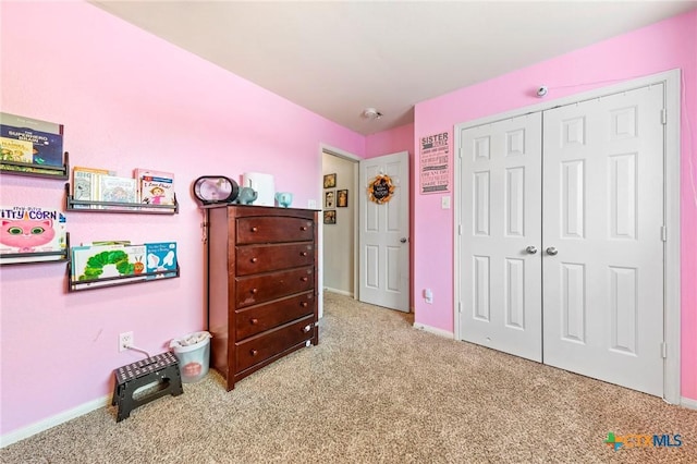 bedroom featuring light colored carpet and a closet