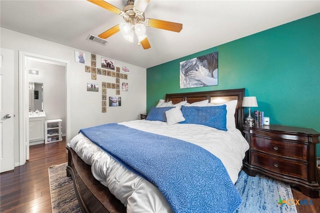 bedroom with ceiling fan, ensuite bath, and dark hardwood / wood-style floors