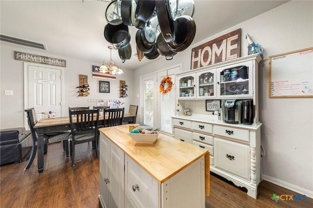 kitchen with decorative light fixtures, dark hardwood / wood-style flooring, white cabinets, and a center island