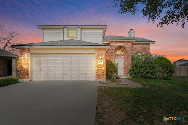 front facade with a garage and a yard