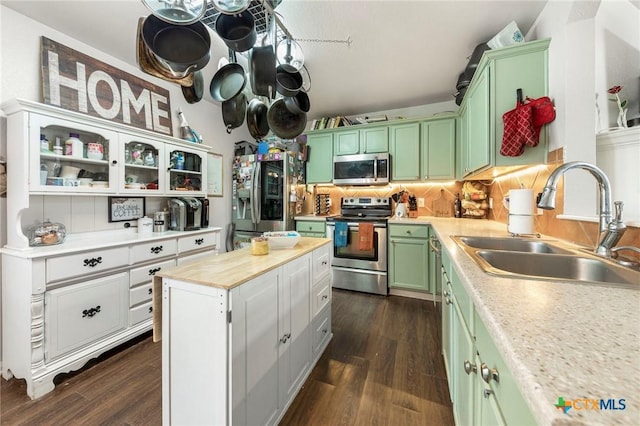 kitchen featuring a center island, sink, green cabinets, dark wood-type flooring, and appliances with stainless steel finishes