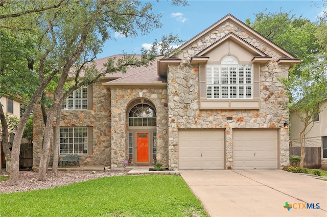 view of front of property featuring a shingled roof, driveway, stone siding, a front lawn, and an attached garage