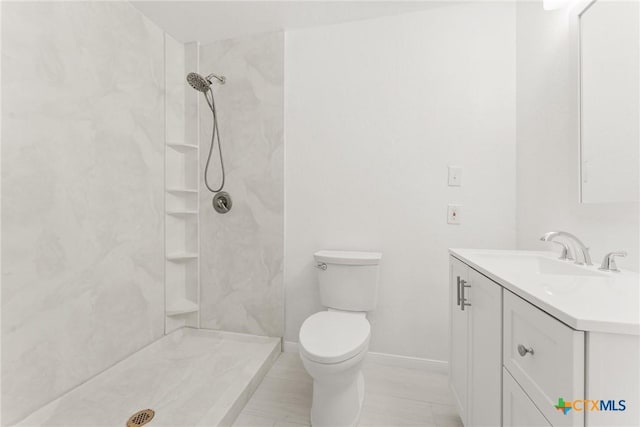 full bathroom featuring baseboards, vanity, toilet, and walk in shower