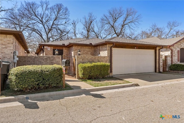 view of front of home with brick siding, a shingled roof, concrete driveway, a gate, and a garage