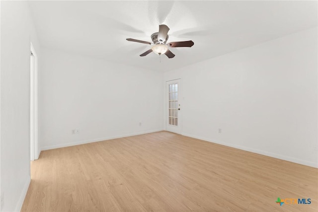 spare room with a ceiling fan, baseboards, and light wood finished floors