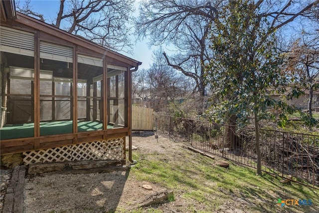 view of yard featuring a sunroom and fence