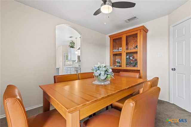 carpeted dining area featuring sink and ceiling fan