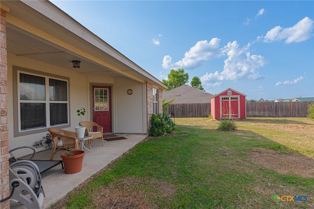 view of yard featuring a storage shed and a patio area