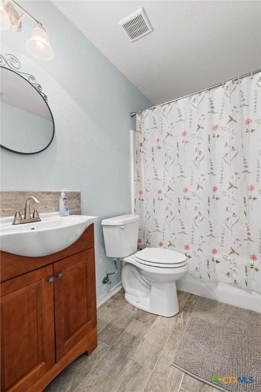 full bathroom with hardwood / wood-style flooring, vanity, toilet, and shower / bath combo