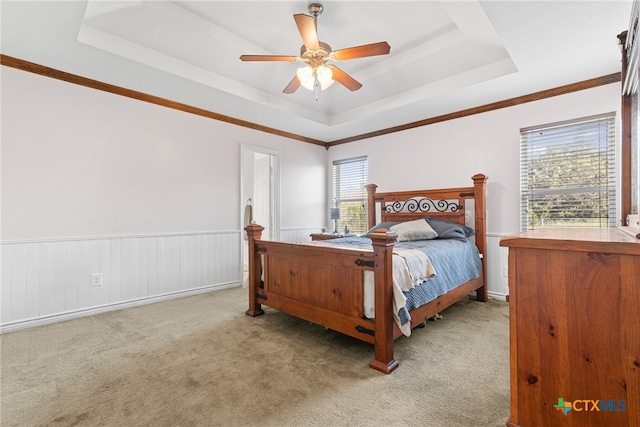 bedroom with ceiling fan, light carpet, and a raised ceiling