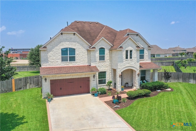 view of front of property featuring a front yard and a garage