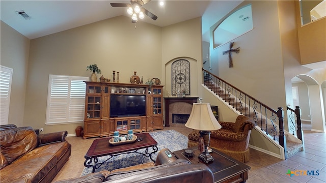 tiled living room featuring ceiling fan and high vaulted ceiling