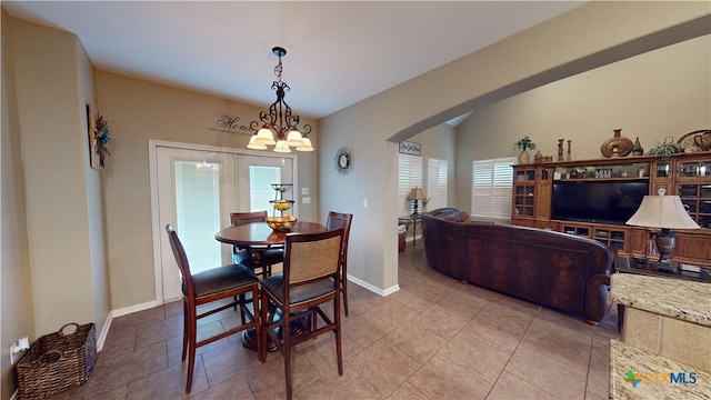 dining space with tile patterned floors, french doors, an inviting chandelier, and plenty of natural light