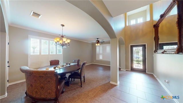 tiled dining space featuring ceiling fan with notable chandelier, plenty of natural light, and crown molding