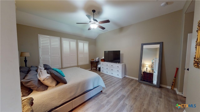 bedroom featuring ceiling fan, lofted ceiling, and light wood-type flooring