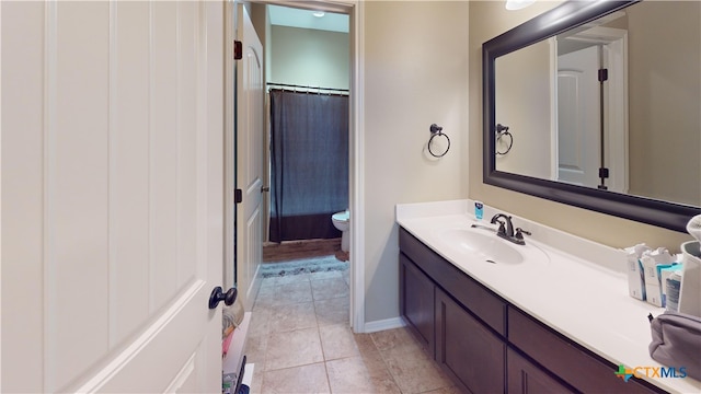 bathroom with tile patterned flooring, vanity, and toilet