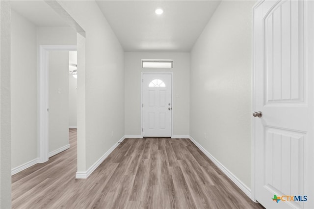 foyer with light wood-type flooring and baseboards