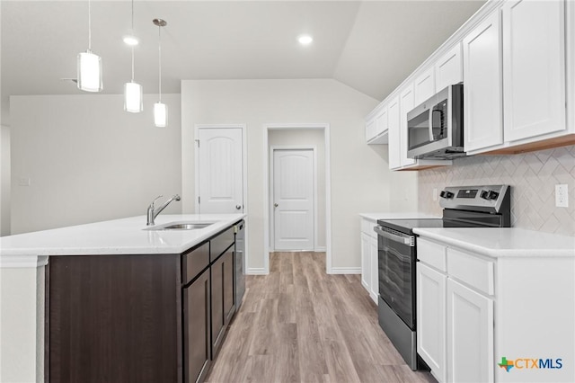 kitchen with a sink, stainless steel appliances, light countertops, and white cabinetry